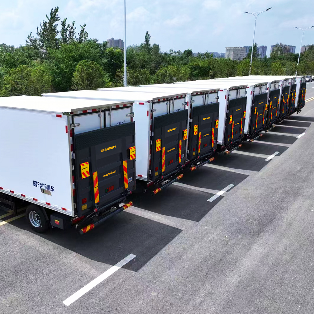 Commercial vehicle fleet with tail lift platforms parked at a warehouse loading yard