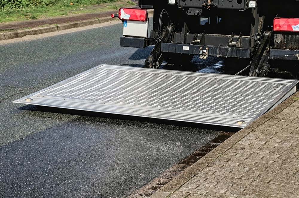 Aluminum tail lift platform lowered flat behind a delivery truck