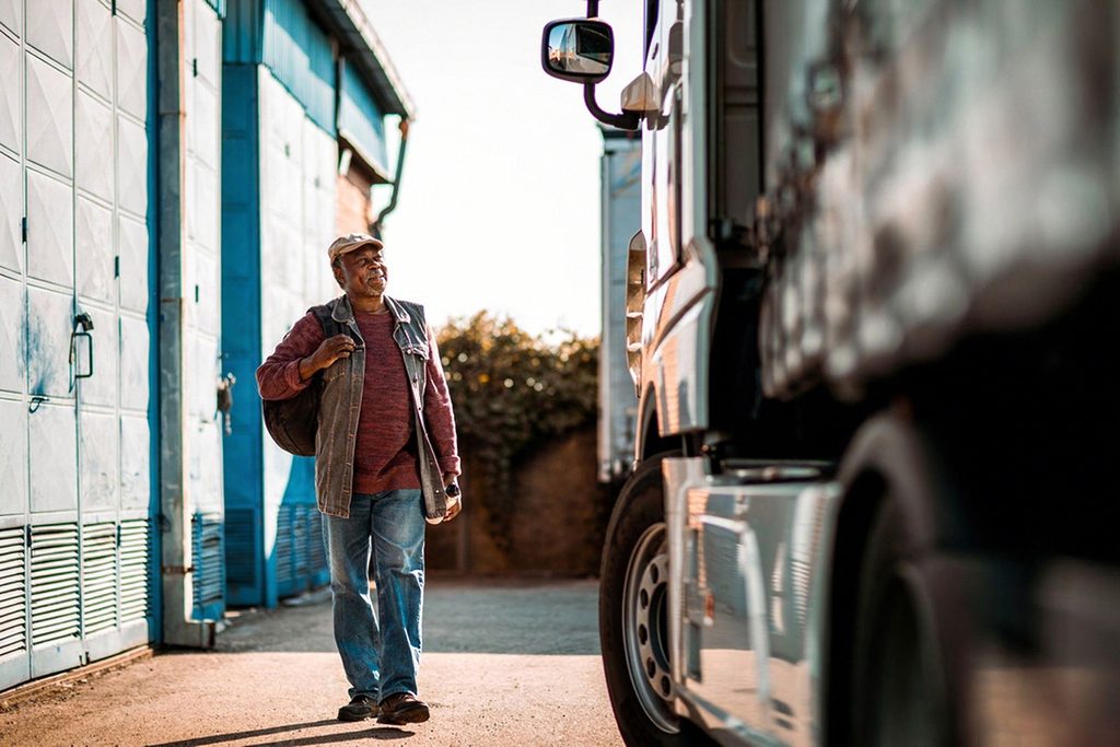 Delivery truck driver walking toward his vehicle equipped with a tail lift