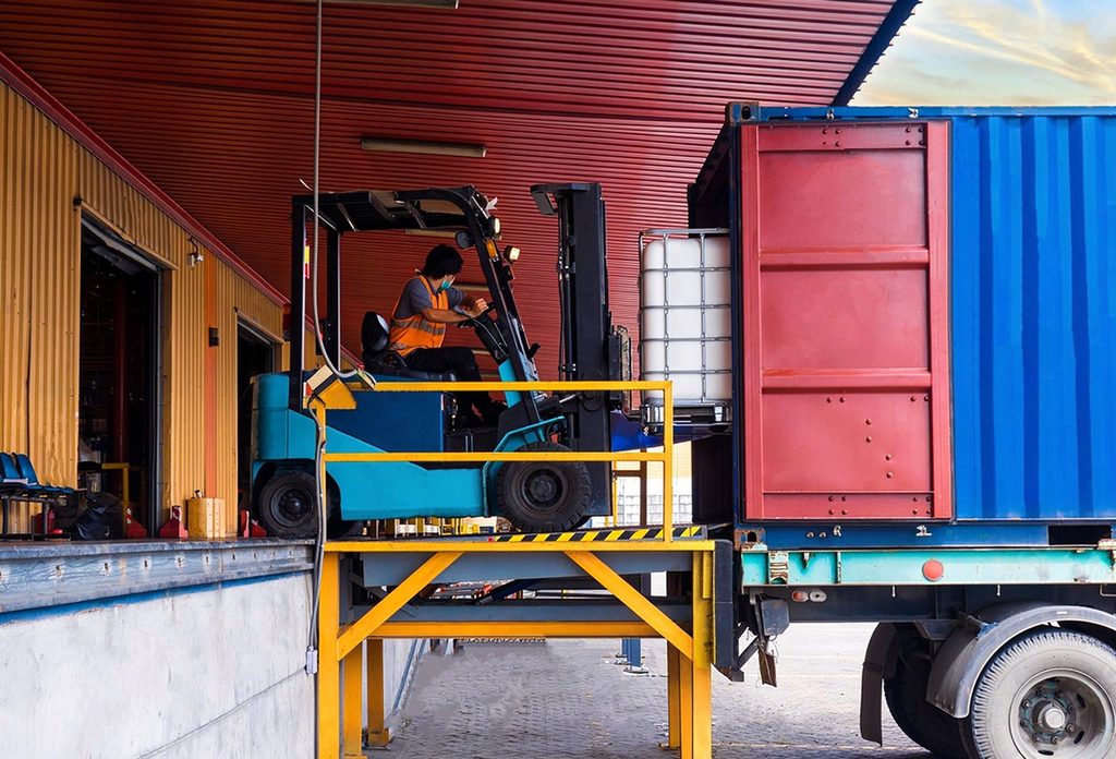 Forklift operating on a loading dock leveler during truck loading